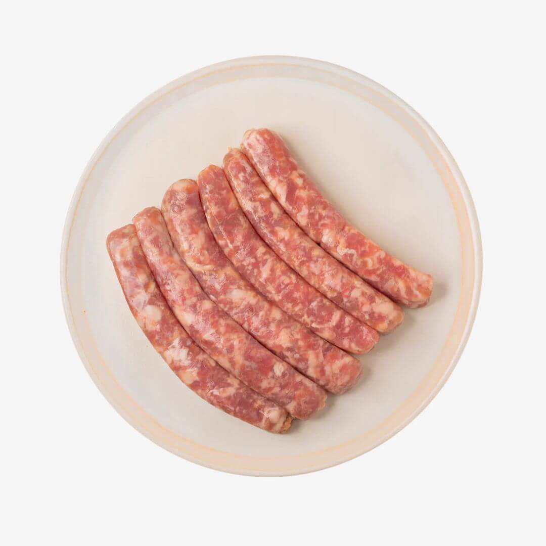 Dufour's Chipolata Sausages on a plate, featuring a finely ground texture and balanced salt and pepper flavor.