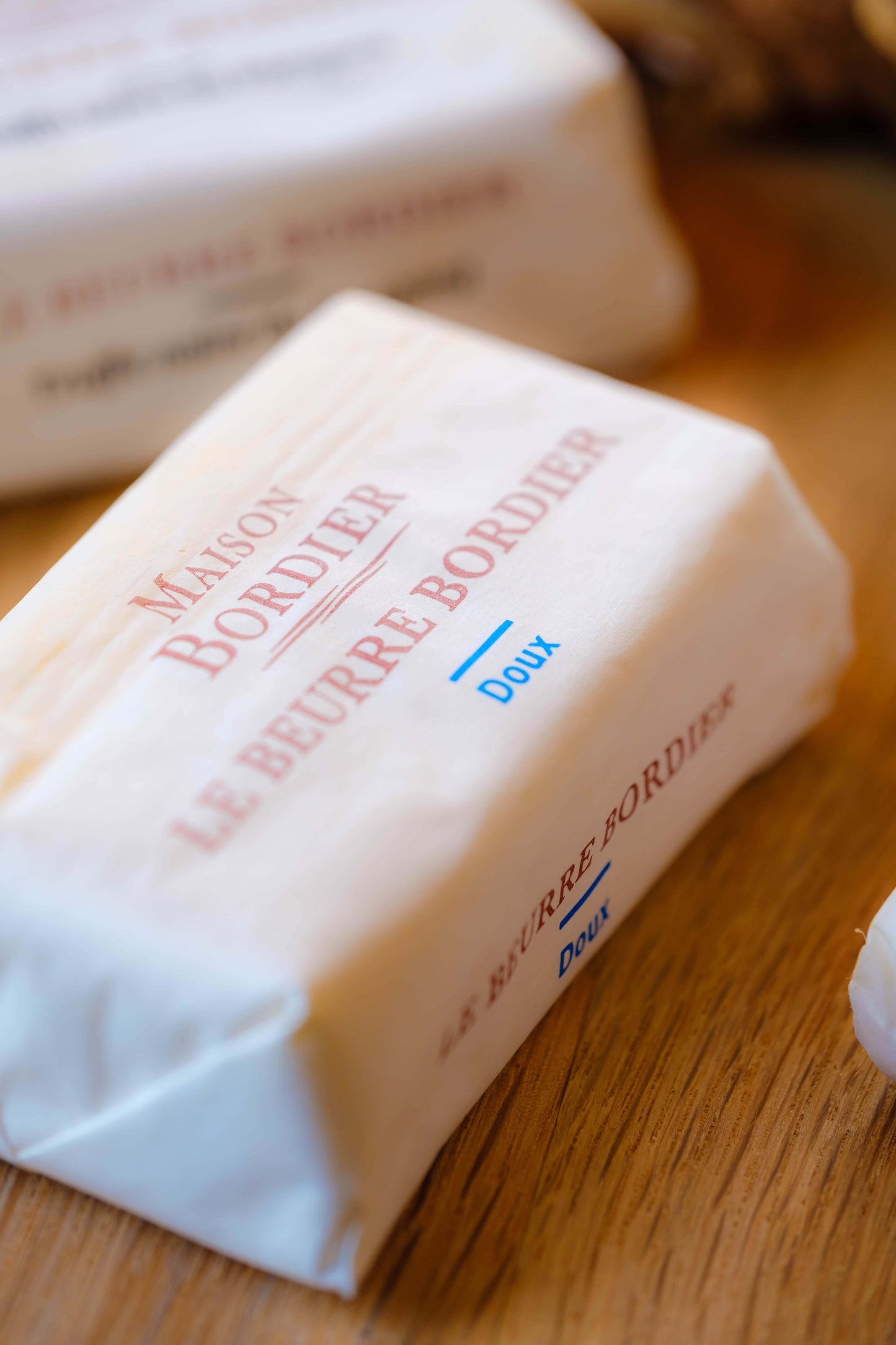 Le Beurre Bordier Unsalted Butter "Doux" packaging on a wooden surface, showcasing its premium quality and French origin.