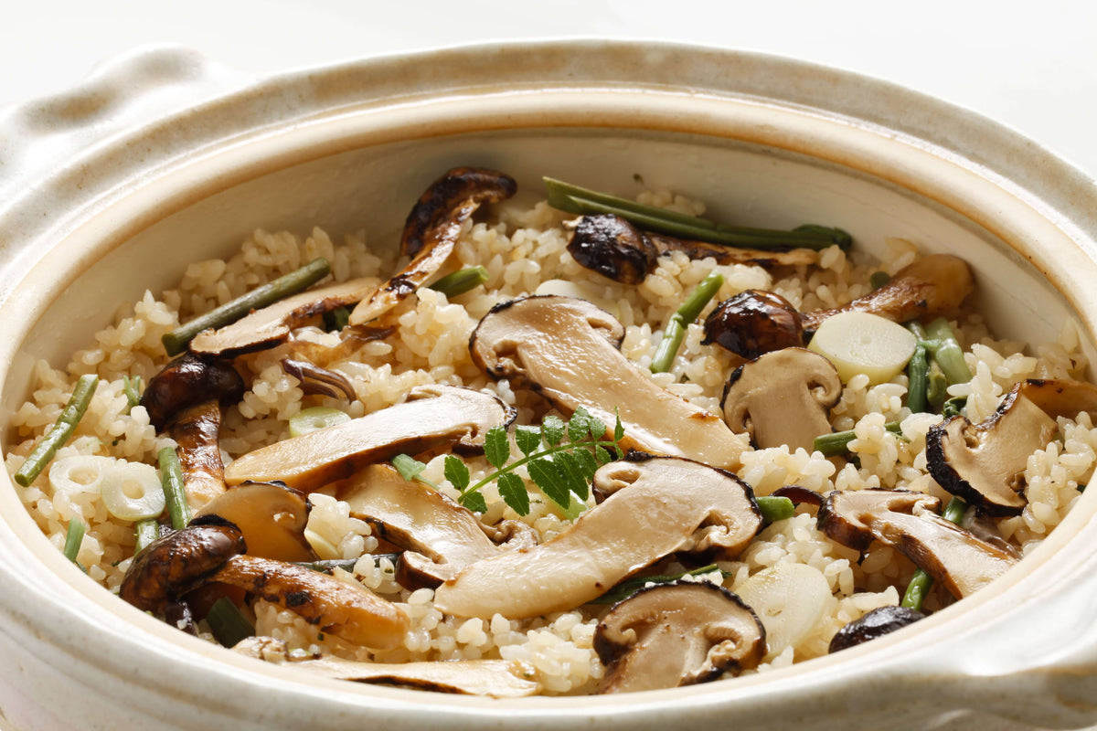 Delicious dish featuring Fresh Matsutake Mushroom over rice, garnished with green onions and herbs.