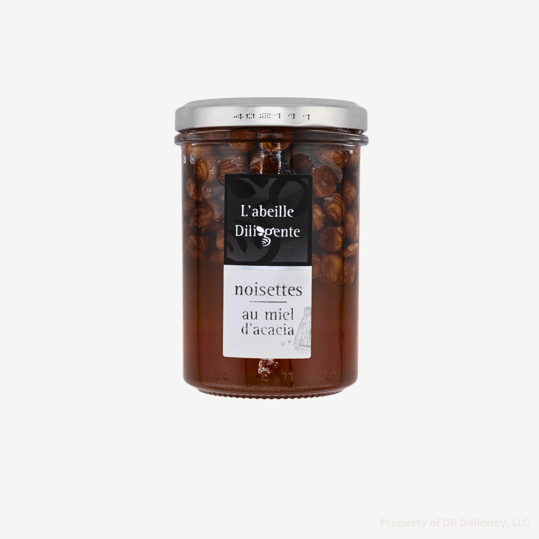 Acacia Honey with Nuts in a jar by L'Abeille Diligente, featuring hazelnuts and rich acacia honey.