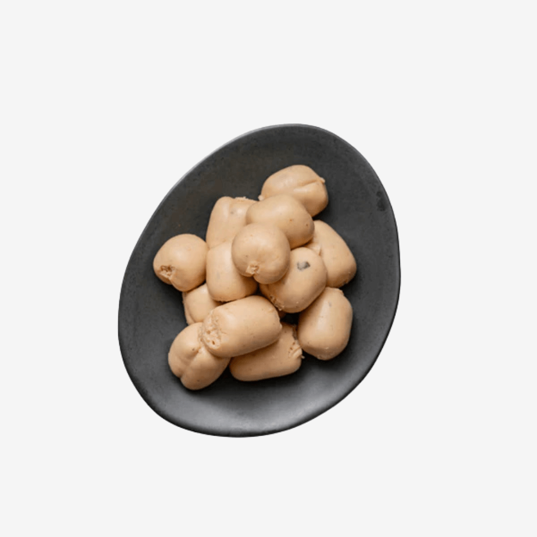 Cocktail Sized Truffle Boudin Blanc Sausage arranged neatly on a black plate, showcasing their creamy texture.