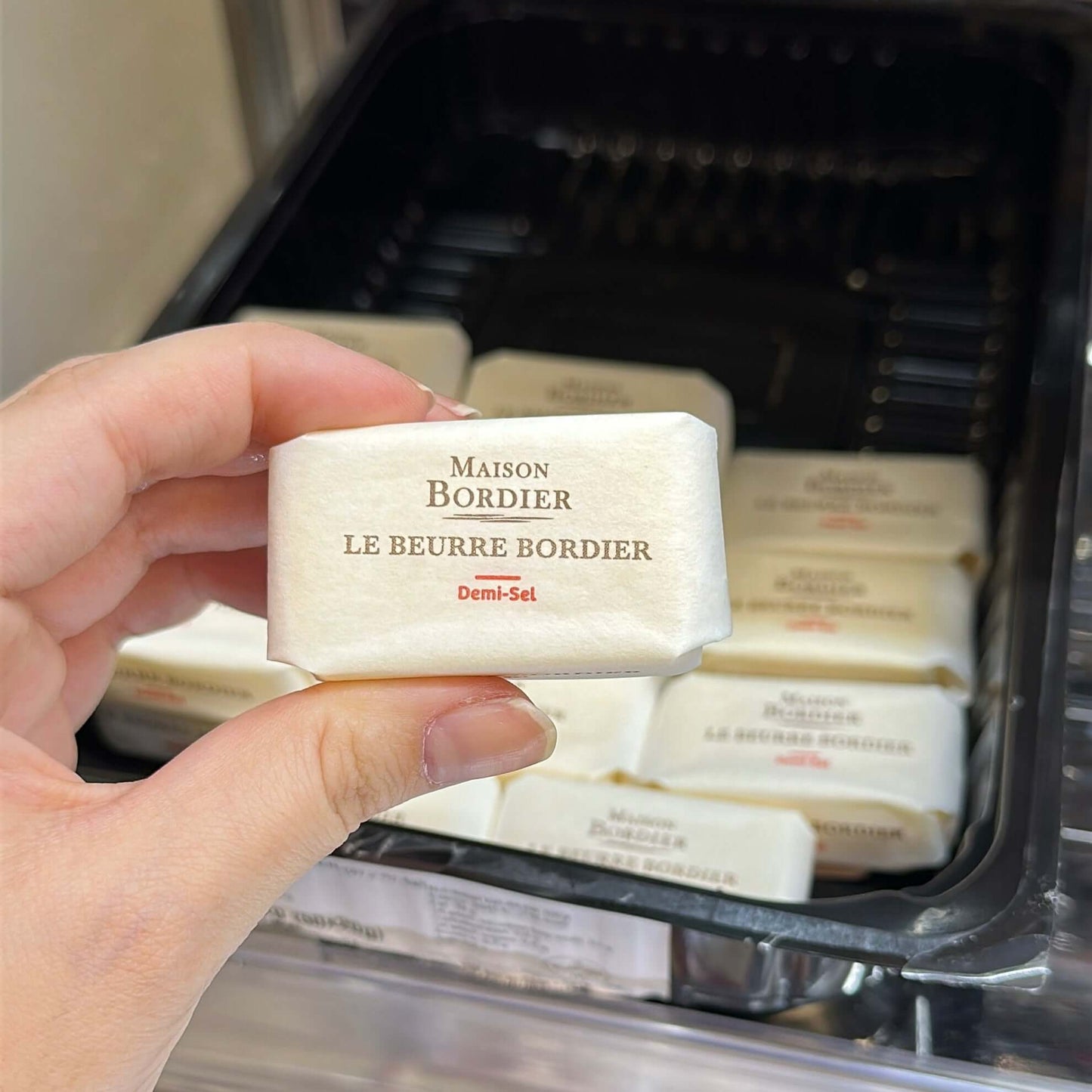Le Beurre Bordier Mini Salted Butter "Demi-Sel" held in hand, showcasing its elegant packaging and label.