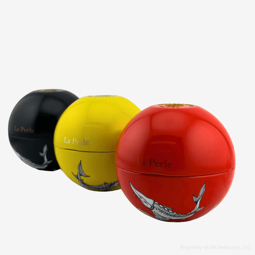 La Perle Caviar Gift Set featuring three elegantly designed caviar containers in black, yellow, and red.