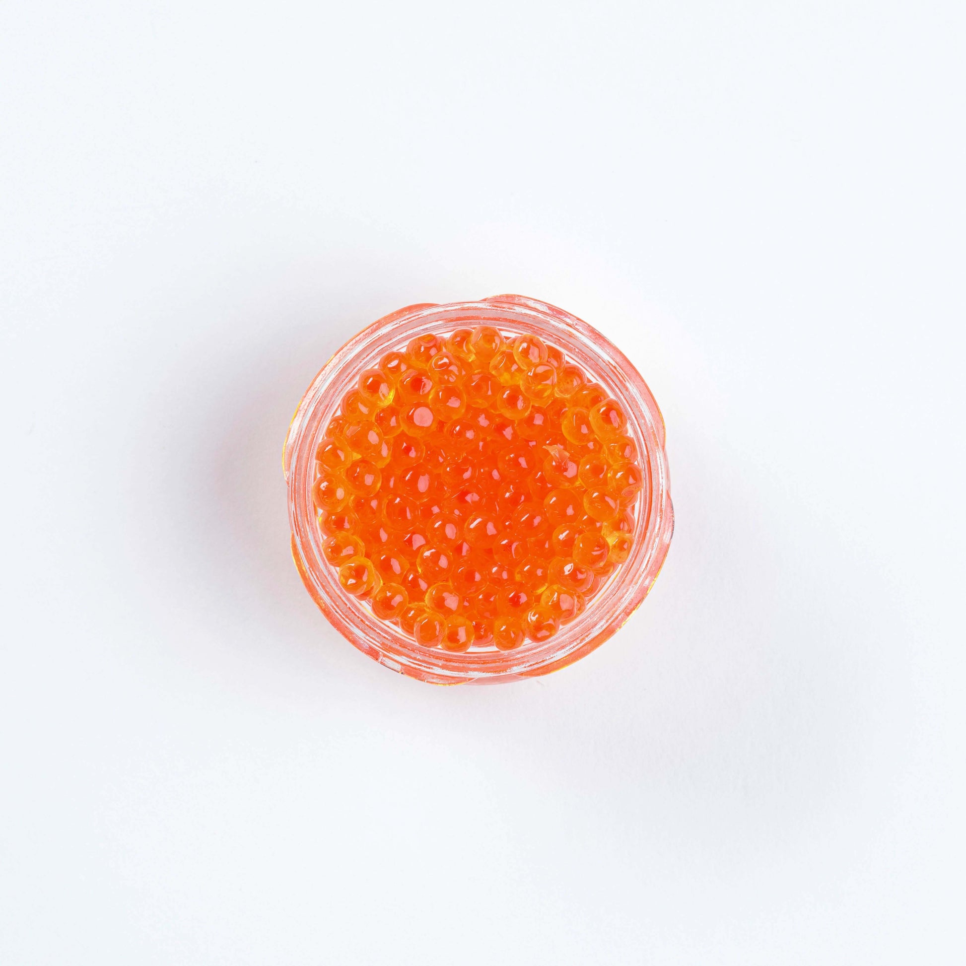 Top view of Keta smoked salmon roe in a clear dish, perfect for enhancing sushi.