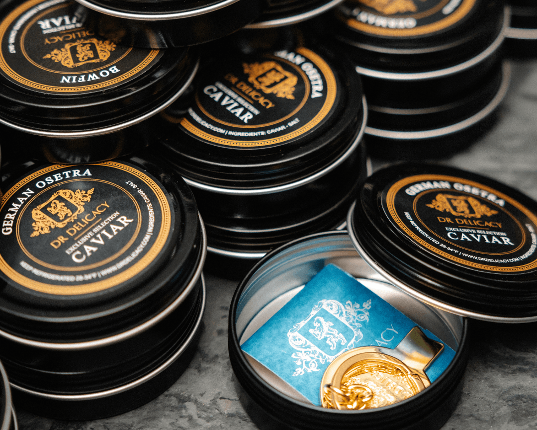 Luxury German Osetra caviar tins stacked with a gold spoon and certificate of authenticity.