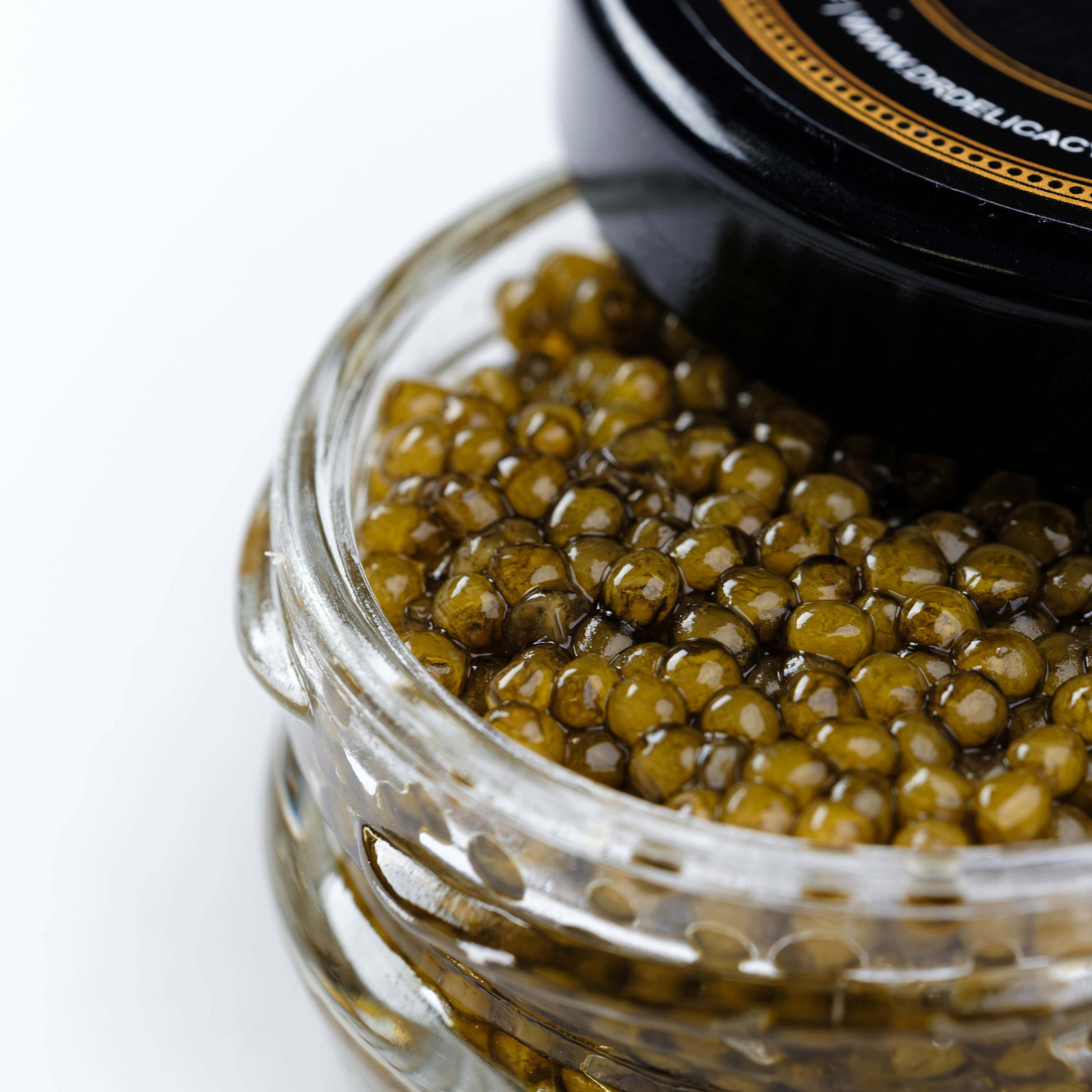 Jar of Osetra Prunier Caviar showcasing medium-sized, amber pearls with a glossy finish.