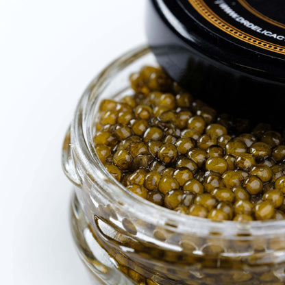 Jar of Osetra Prunier Caviar showcasing medium-sized, amber pearls with a glossy finish.
