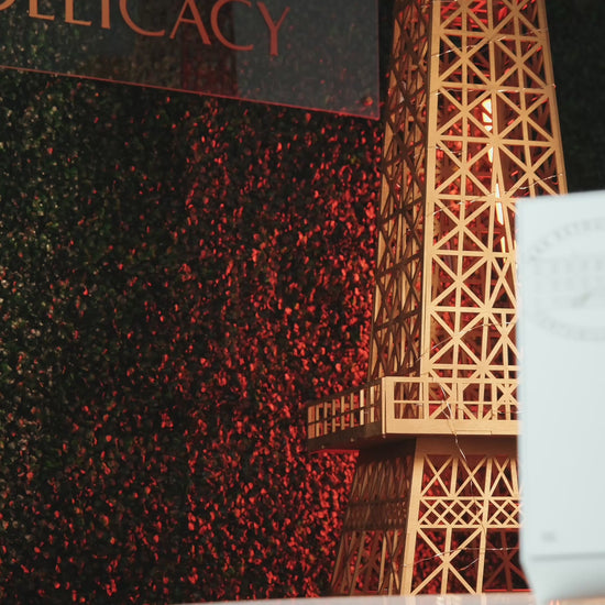 Eiffel Tower model at Delicacy event with decorative background and soft lighting